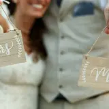 Para młoda trzyma tabliczki "Mrs" i "Mr". Zastanawiasz się, ile czasu na zmianę dokumentów po ślubie?