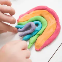 Dziecko tworzy tęczę z kolorowej ciastoliny. Prosty przepis na domową ciastolinę to świetna zabawa.