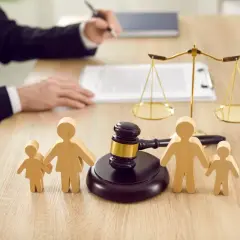 Drewniane figurki rodziny, młotek sędziowski i waga symbolizują problemy z bezskutecznością egzekucji alimentów.