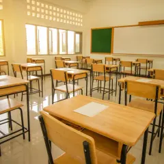 Puste ławki w sali lekcyjnej, gotowe na uczniów. Czy szkoła średnia jest obowiązkowa? To pytanie zadaje sobie wielu młodych ludzi.