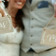 Para młoda trzyma tabliczki "Mrs" i "Mr". Zastanawiasz się, ile czasu na zmianę dokumentów po ślubie?