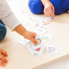Dziecko bawi się kartami z obrazkami i literami, ucząc się słówek. Radość z zabawy z dzieckiem.