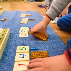 Dzieci bawią się matematycznie, układając klocki z cyframi i koraliki.