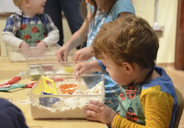 Dzieci bawią się masą sensoryczną, tworząc piaskowe zamki. Świetne zabawy sensoryczne dla 7 latka!