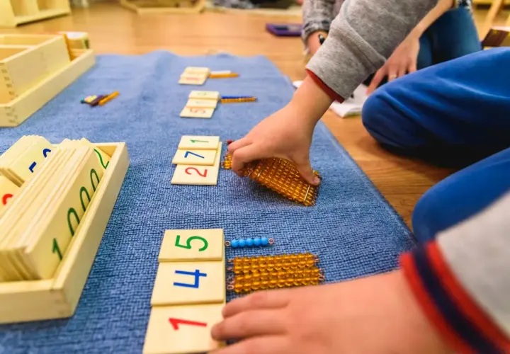 Dzieci bawią się matematycznie, układając klocki z cyframi i koraliki.
