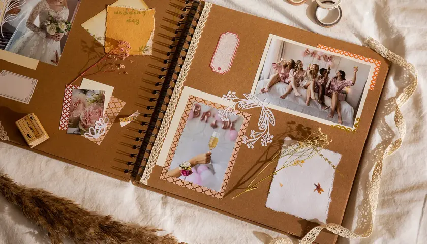Oto jak wygląda scrapbooking: album z pamiątkami ślubnymi, zdjęciami panny młodej i jej druhen, ozdobiony taśmami i suszonymi kwiatami.
