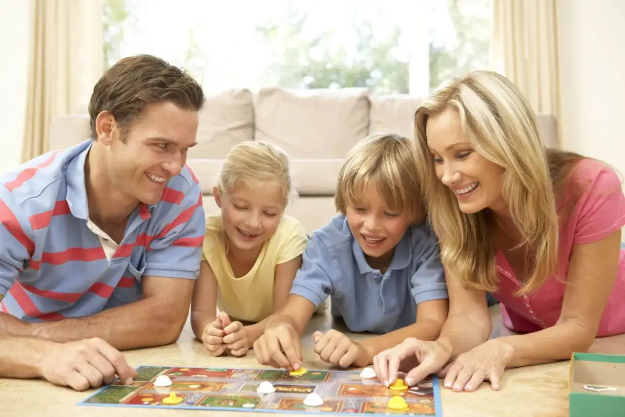 Rodzina gra w popularne gry dla dzieci. Radość i śmiech towarzyszą rozgrywce.
