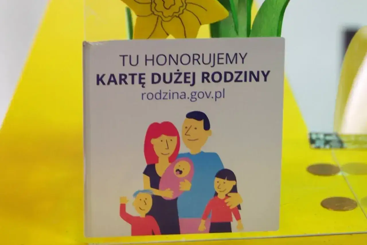 Karta Dużej Rodziny, symbol wsparcia dla rodzin, może pomóc w uzyskaniu dodatku energetycznego. Ilustracja przedstawia szczęśliwą rodzinę.