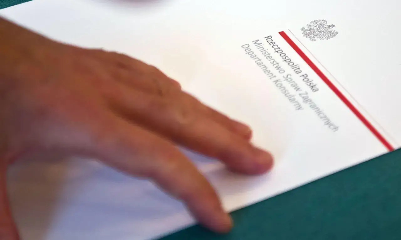 Dłoń na dokumencie Ministerstwa Spraw Zagranicznych. Ktoś stara się o polskie obywatelstwo, ale dokumenty nie są kompletne.