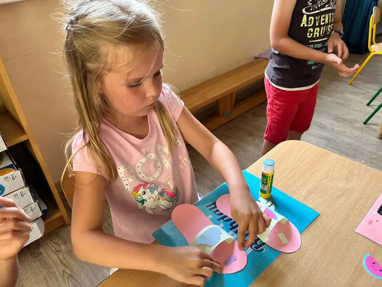 Dziewczynka tworzy klapki z papieru, świetne pomysły na warsztaty dla dzieci.